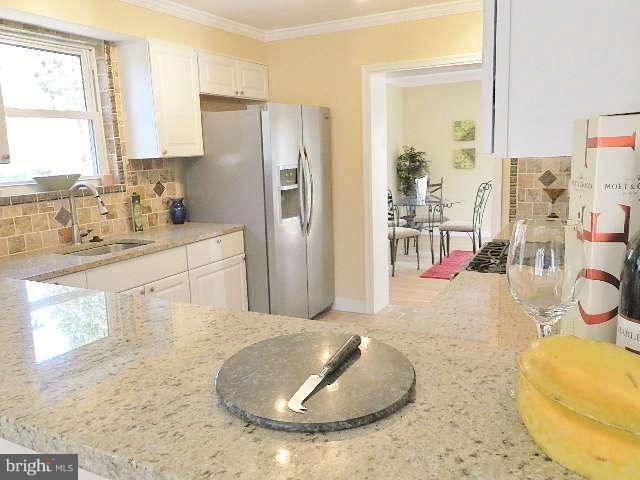 11611 Gail Street Silver Spring, MD 20902 - Photo 17 of 30 a kitchen with stainless steel appliances granite countertop a sink a stove and a refrigerator