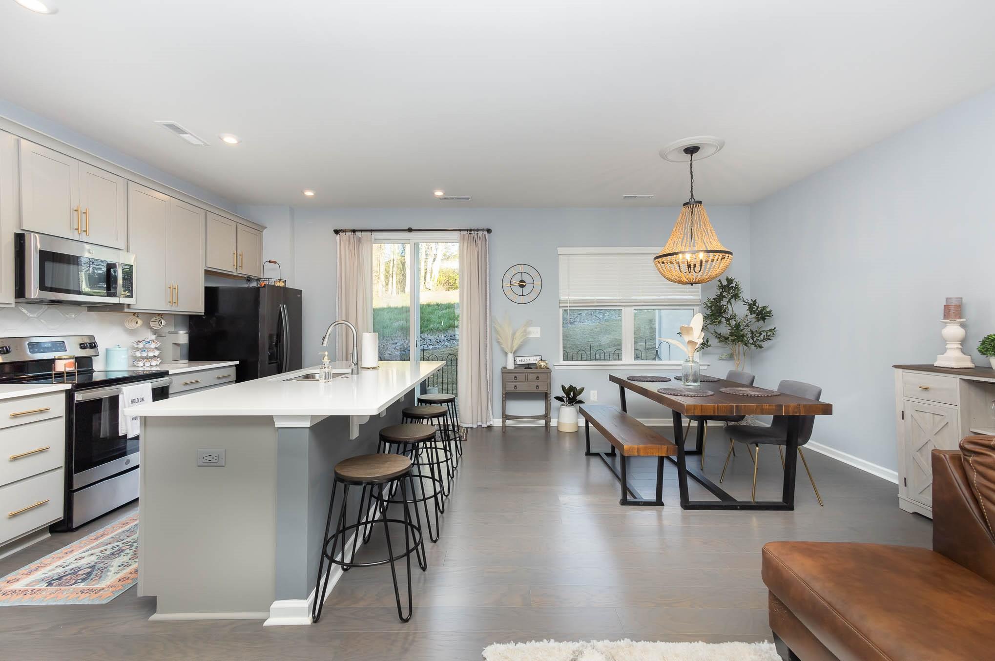 514 Madison Falls Fort Mill, SC 29708 - Photo 13 of 29 a kitchen with stainless steel appliances a dining table chairs and a refrigerator