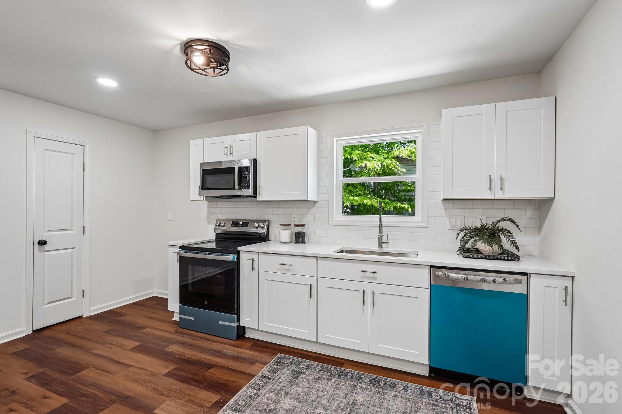 514 West Arch Street Lancaster, SC 29720 - Photo 7 of 43 a kitchen with a stove a sink and a microwave