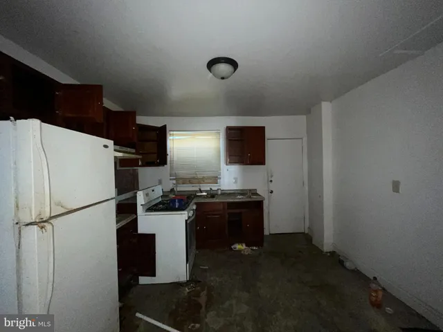 a kitchen with a refrigerator and a stove top oven