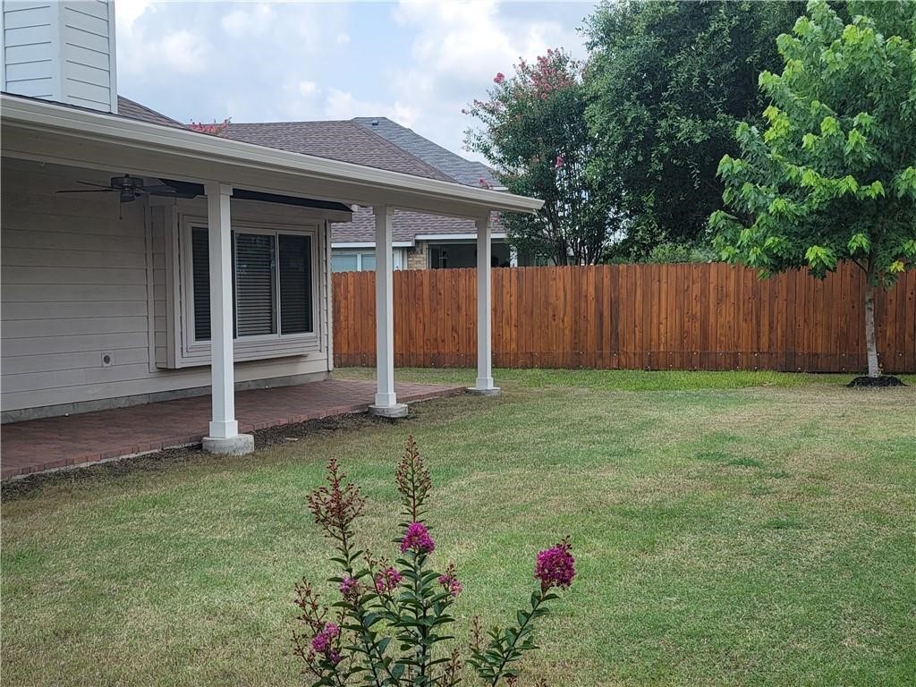 208 Hummingbird Lane Leander, TX 78641 - Photo 19 of 25 A well-maintained lawn with a privacy fence and a charming covered patio for outdoor enjoyment.