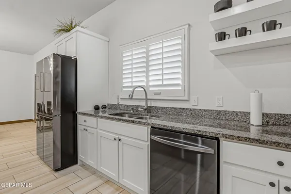 a kitchen with stainless steel appliances granite countertop a sink and a refrigerator