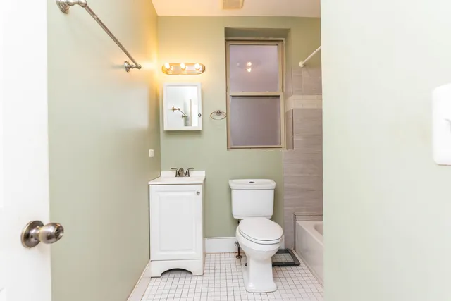 a bathroom with a toilet and a mirror