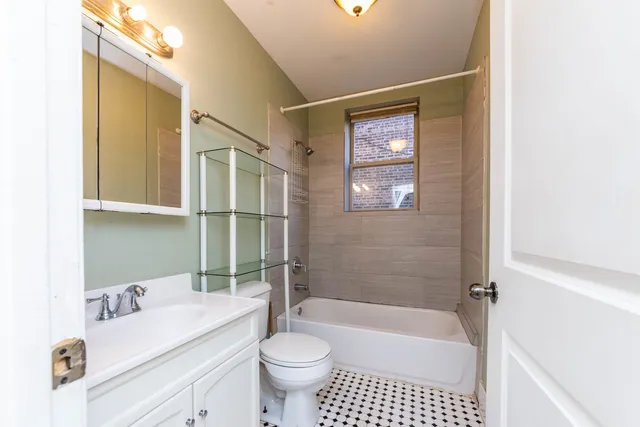 a bathroom with a sink a toilet a mirror a bathtub and shower