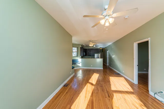 a view of a room with wooden floor and ceiling fan