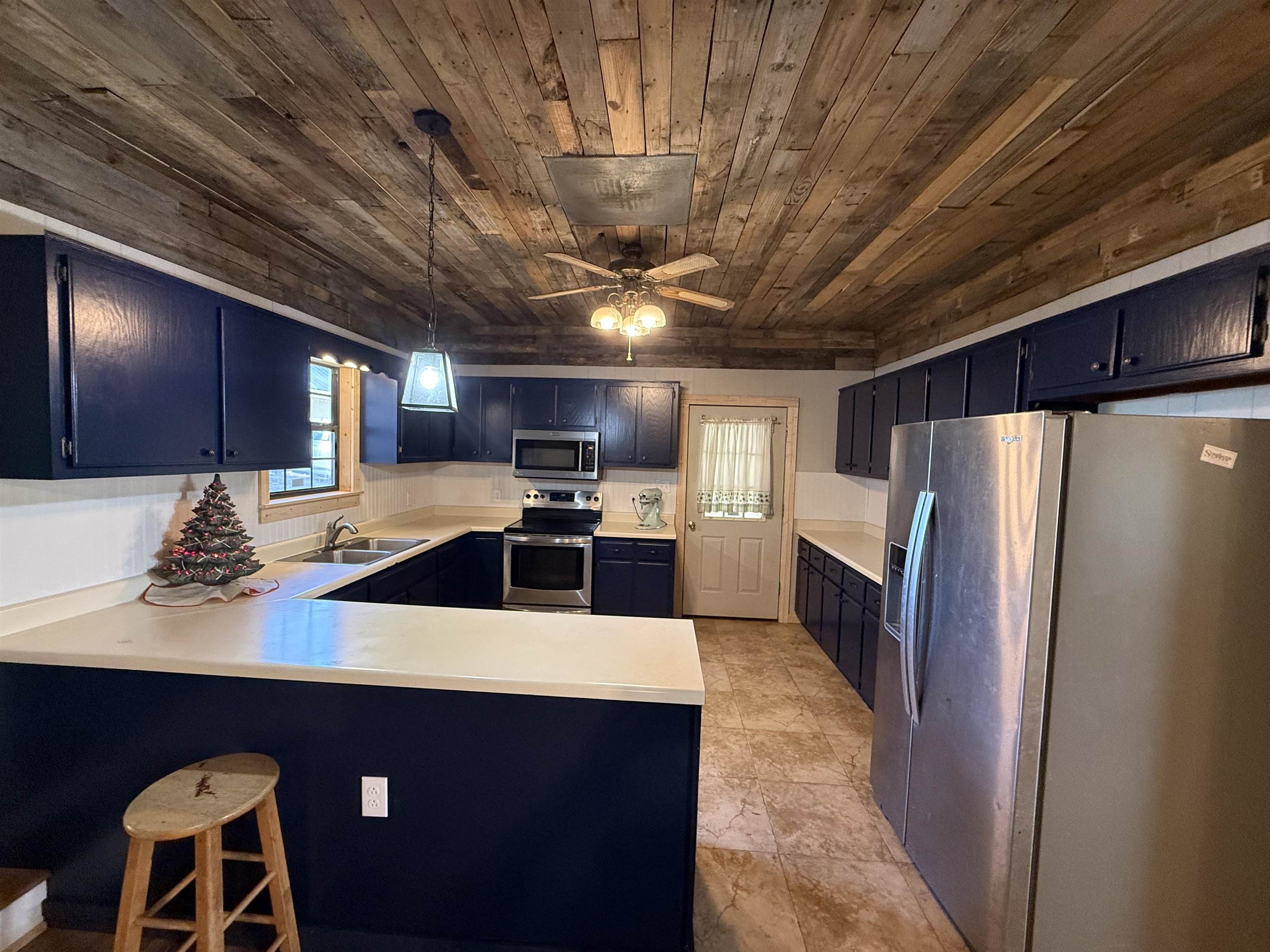 2142 Highway 70 Mason, TN 38049 - Photo 10 of 36 Kitchen with stainless steel appliances, light countertops, a peninsula, a kitchen bar, and decorative light fixtures