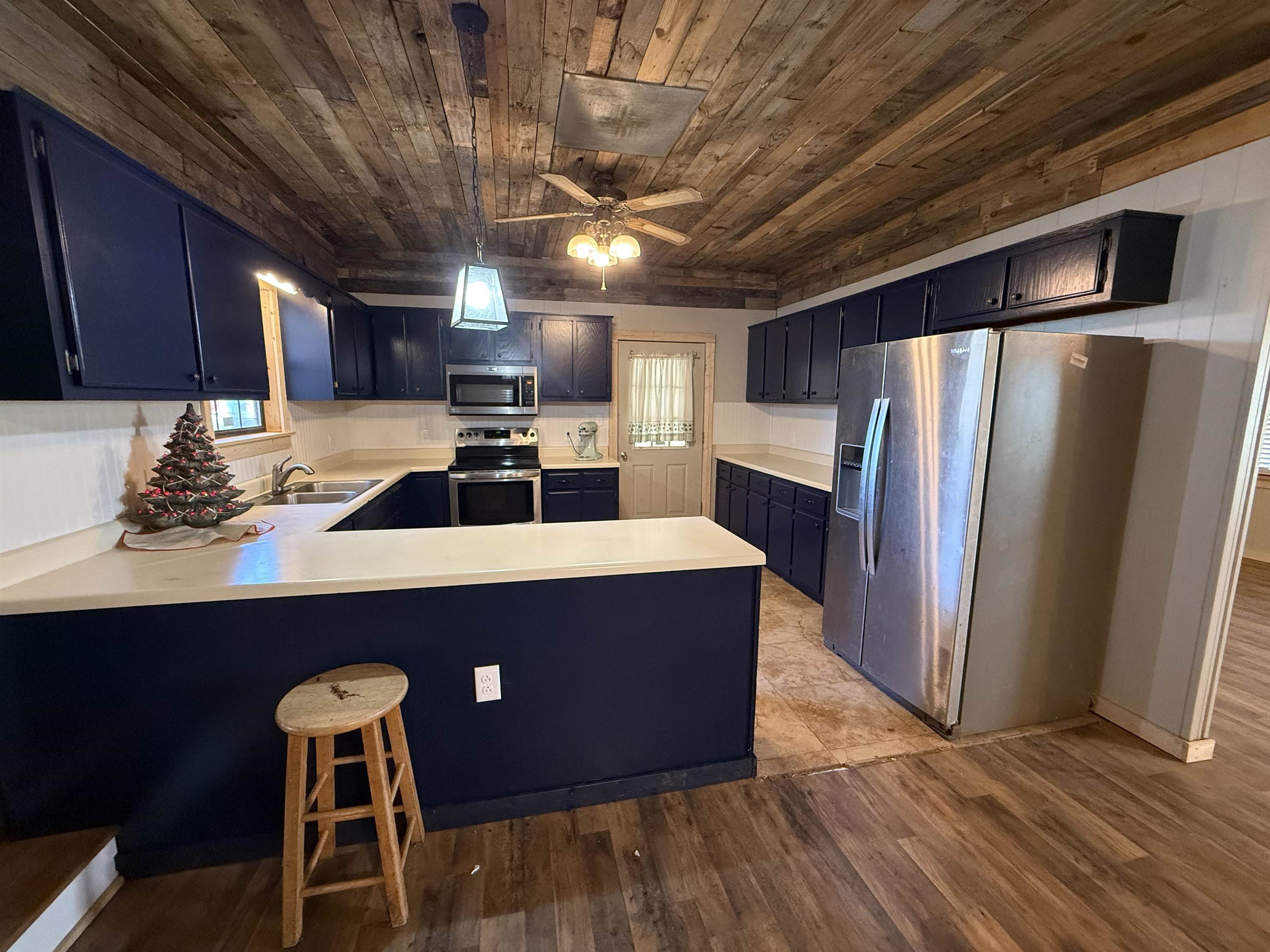 2142 Highway 70 Mason, TN 38049 - Photo 11 of 36 Kitchen featuring stainless steel appliances, blue cabinets, light countertops, a peninsula, and light wood finished floors
