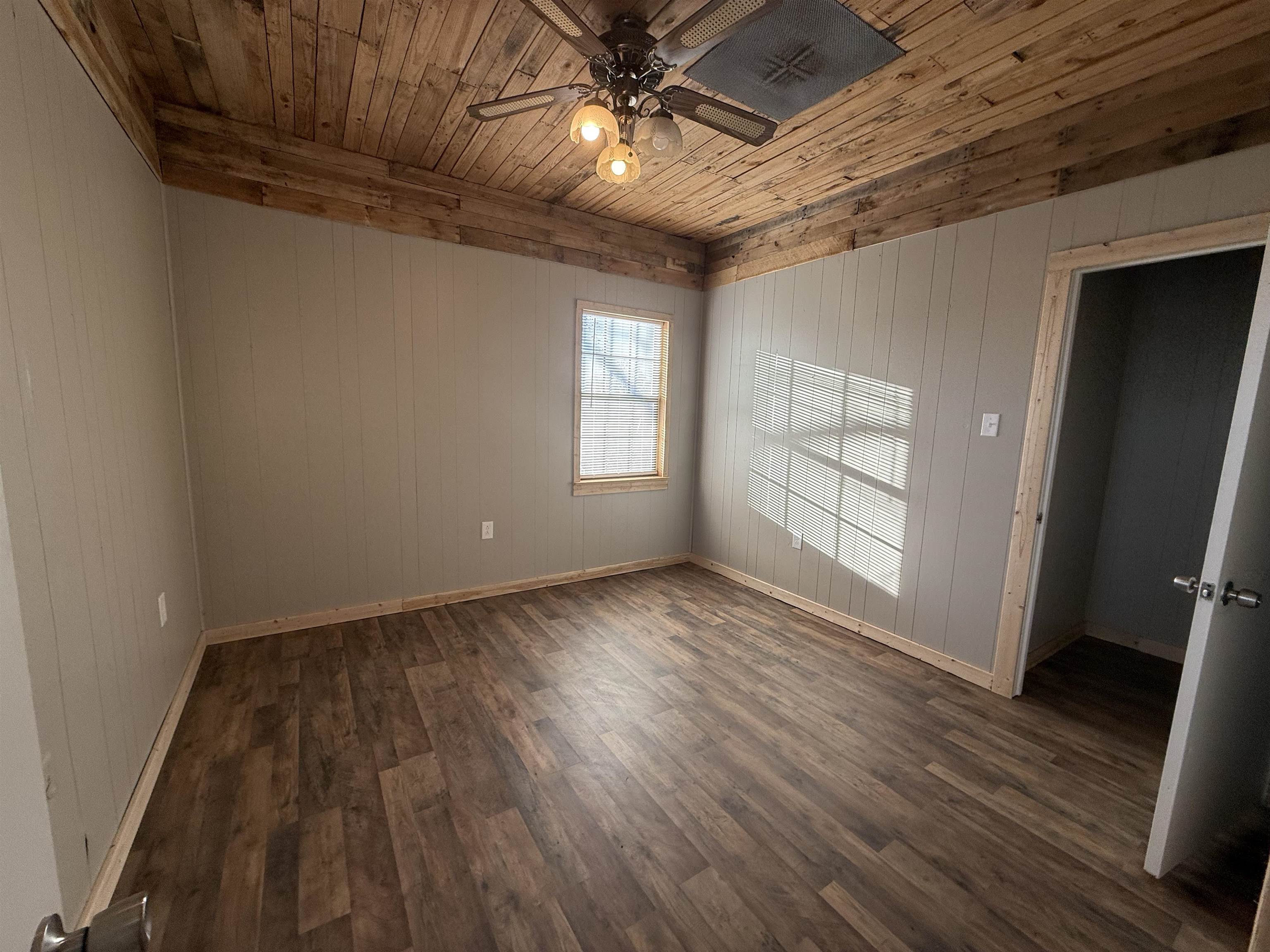 2142 Highway 70 Mason, TN 38049 - Photo 24 of 36 Bedroom with wood ceiling, ceiling fan, dark wood-style flooring, and wood walls