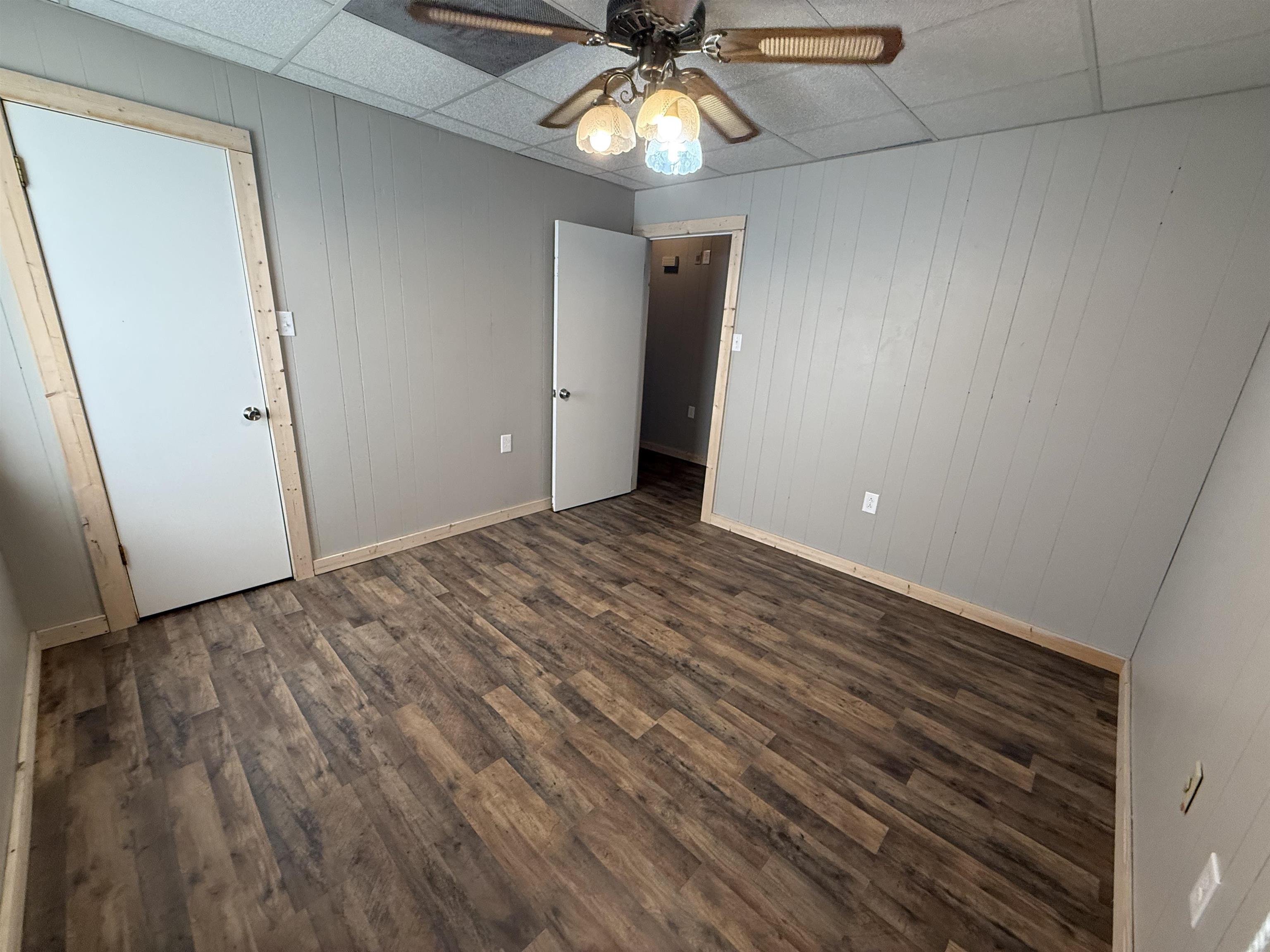 2142 Highway 70 Mason, TN 38049 - Photo 25 of 36 Unfurnished bedroom with wood walls, a paneled ceiling, dark wood-type flooring, and a ceiling fan
