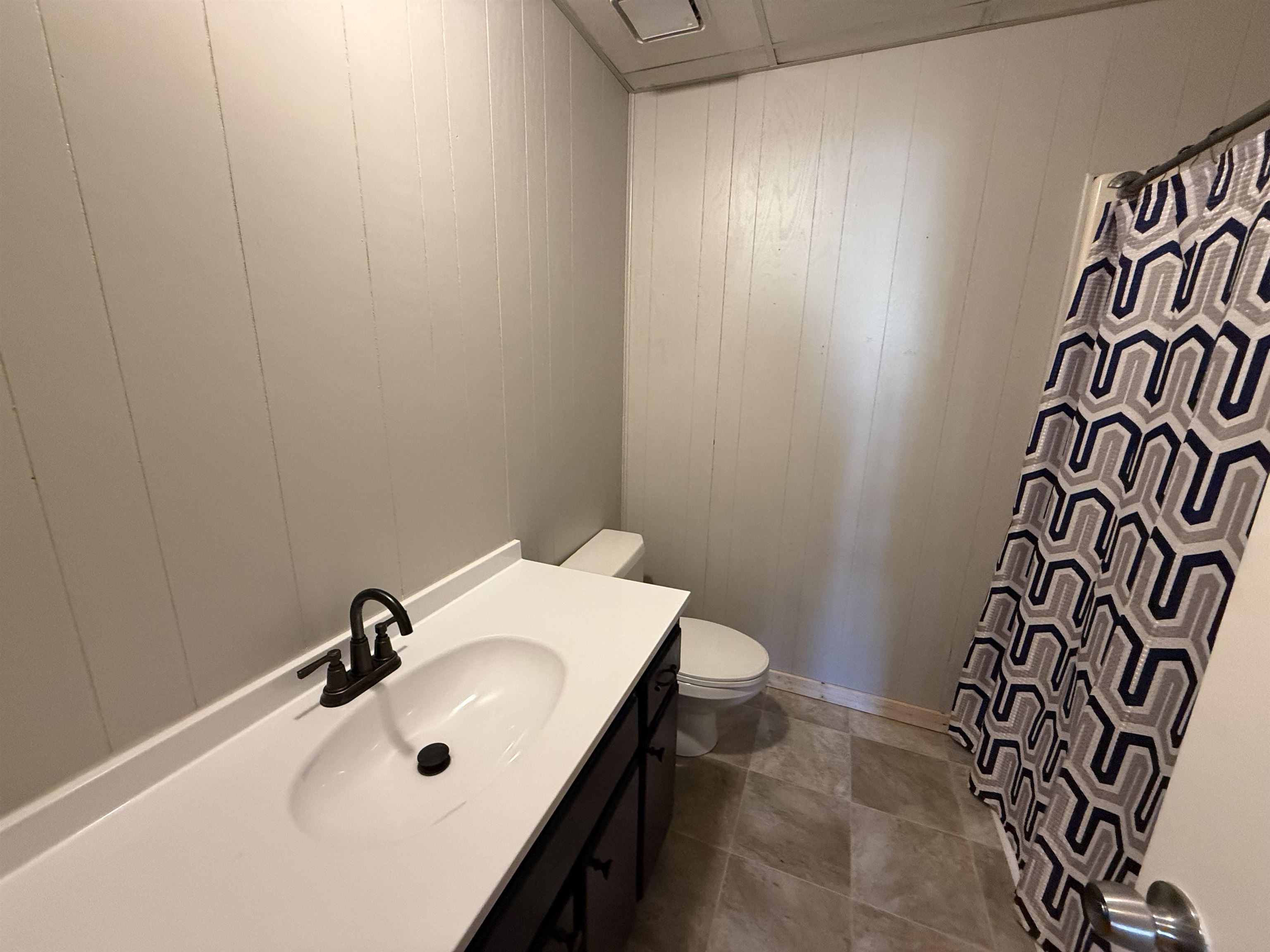 2142 Highway 70 Mason, TN 38049 - Photo 27 of 36 Full bathroom with vanity, curtained shower, and wood walls