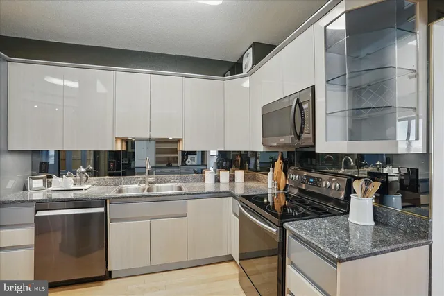 a kitchen with a sink a refrigerator and cabinets
