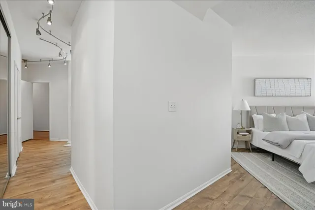 a view of a hallway with wooden floor and closet