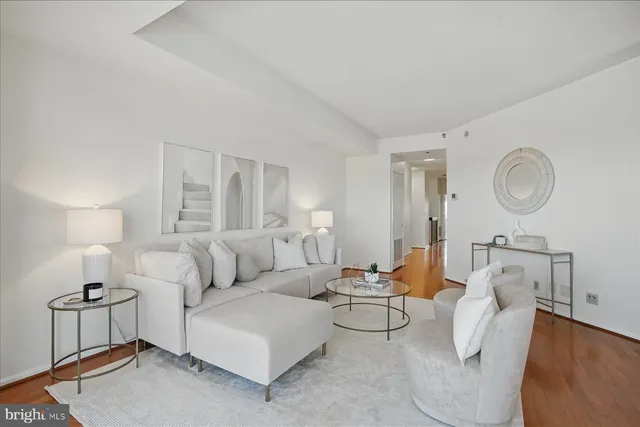 a living room with furniture a rug and a lamp