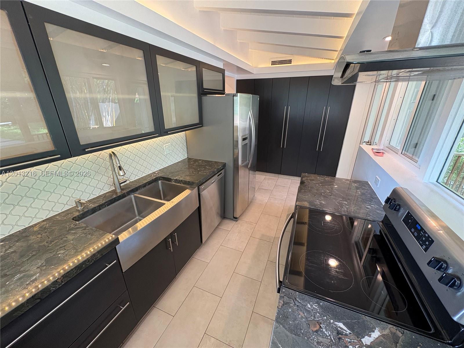 250 Southwest 19th Road Miami, FL 33129 - Photo 14 of 22 a kitchen with stainless steel appliances granite countertop a sink and a stove