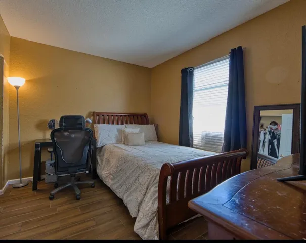 a bedroom with a bed and wooden floor