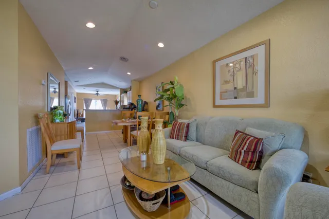 a living room with furniture and a dining table with kitchen view