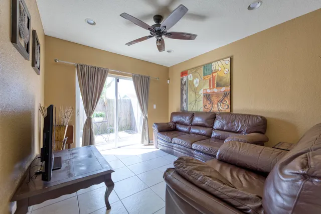 a living room with furniture a flat screen tv and a large window