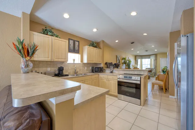a kitchen with stainless steel appliances granite countertop a sink and a refrigerator