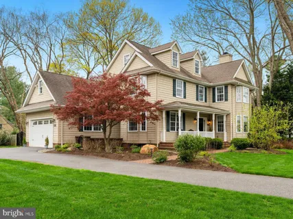 a front view of a house with a garden and trees