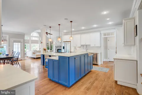 a kitchen with stainless steel appliances granite countertop a sink a stove and a wooden floors