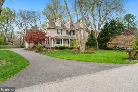 a view of a house with a yard and large tree