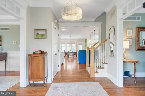 a kitchen with stainless steel appliances granite countertop a refrigerator a sink dishwasher a oven and a dining table with wooden floor