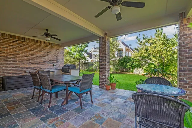a patio with table and chairs and potted plants