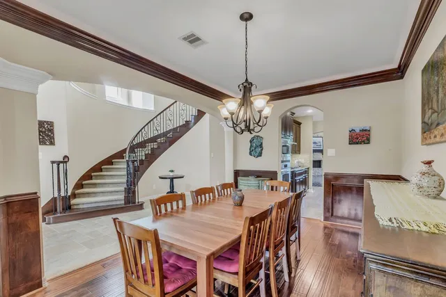 a view of a dining room and livingroom with furniture wooden floor a chandelier