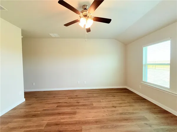 an empty room with a window and a ceiling fan