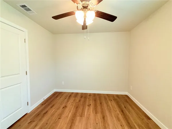 a view of an empty room with wooden floor