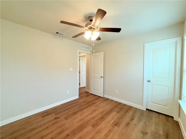 a view of an empty room with wooden floor