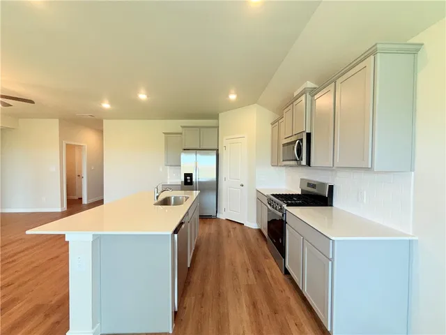 a kitchen with kitchen island a sink a stove and a refrigerator