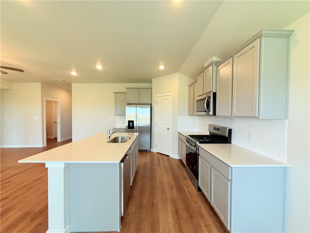 1116 Zeus Portland, TX 78374 - Photo 8 of 39 a kitchen with kitchen island a sink a stove and a refrigerator