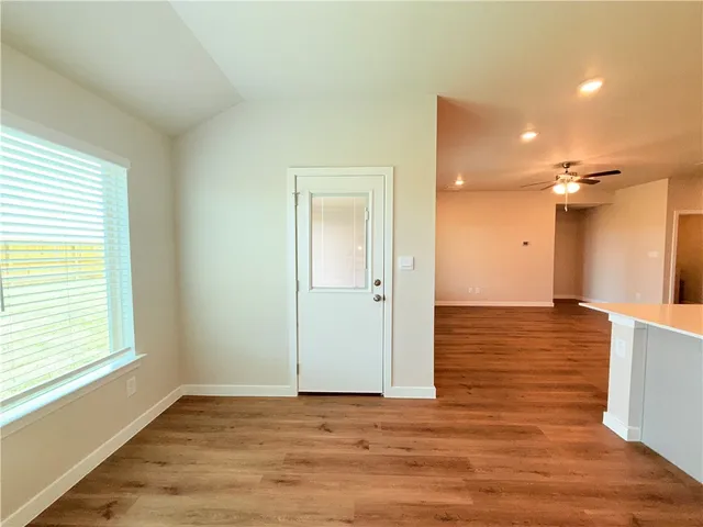 a view of a room with wooden floor and a window