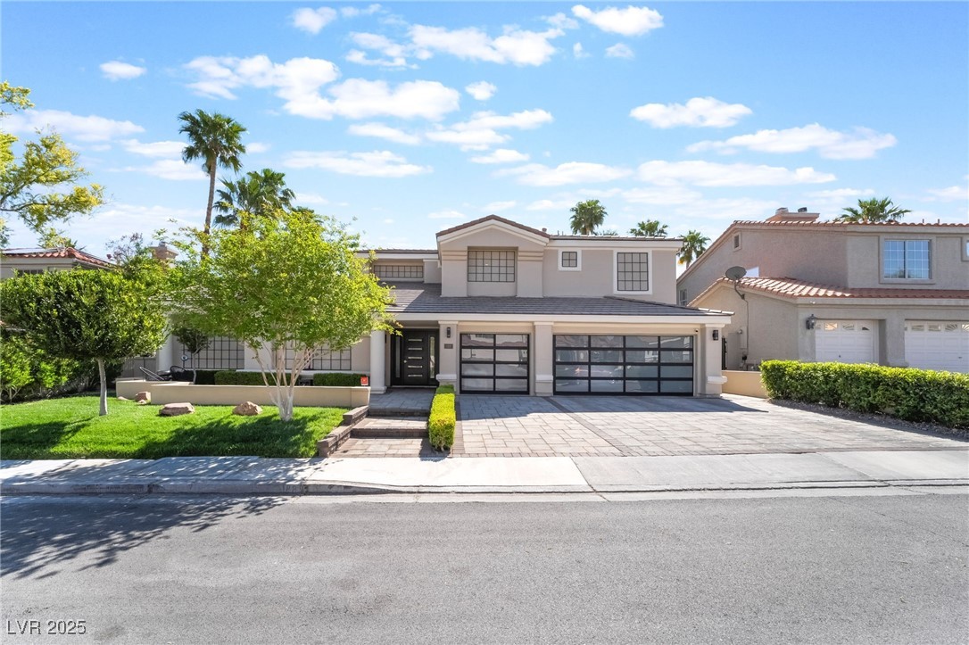 View of front of house with a garage, driveway, an