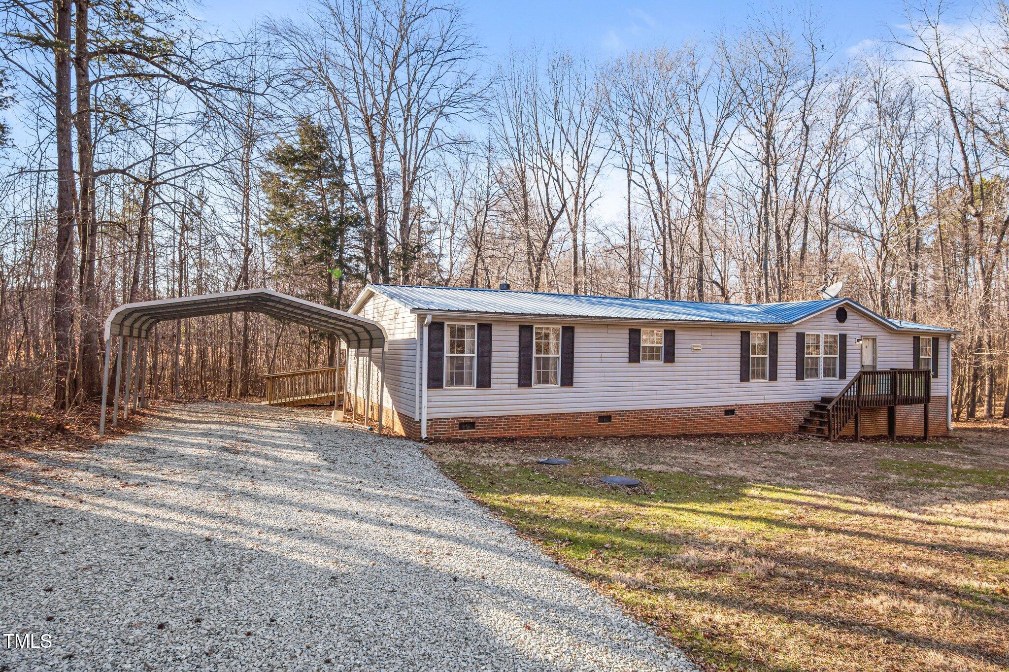 149 Michael Jones Road Roxboro, NC 27574 - Photo 24 of 32 a front view of a house with a yard covered with trees