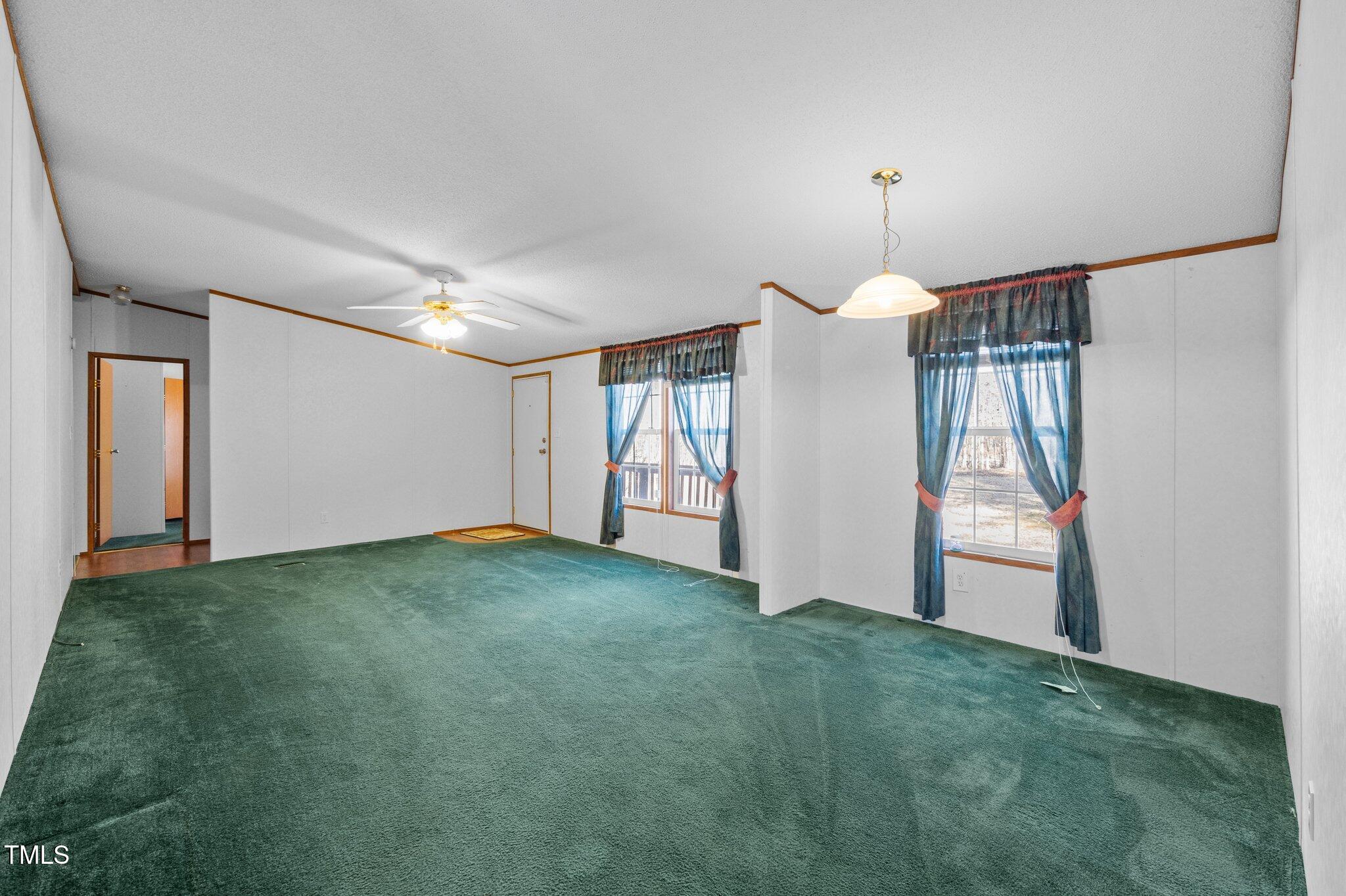 149 Michael Jones Road Roxboro, NC 27574 - Photo 5 of 32 a view of an empty room with chandelier fan and a window