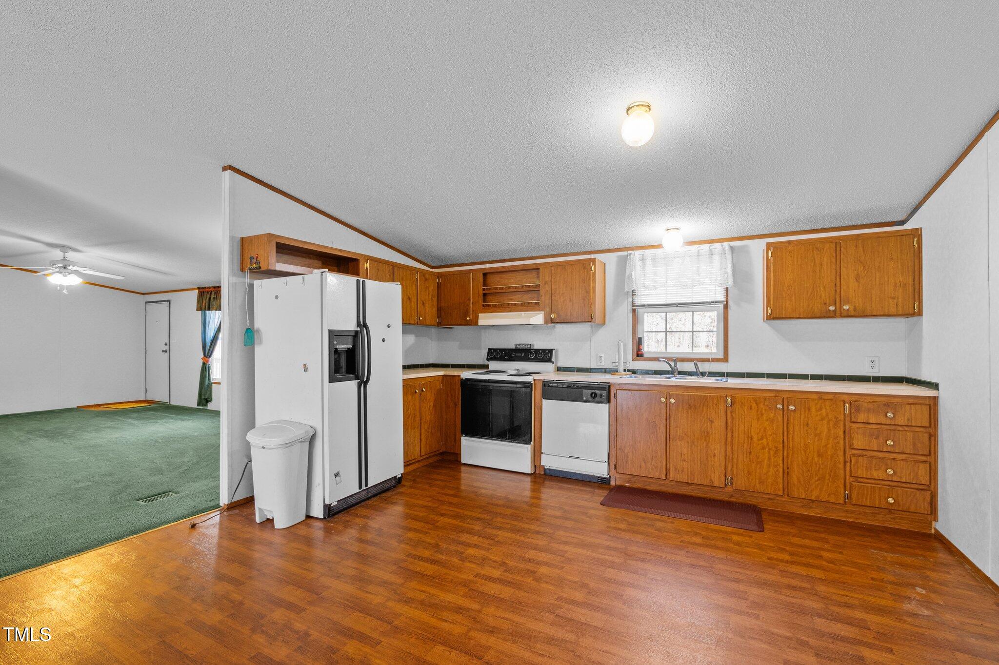 149 Michael Jones Road Roxboro, NC 27574 - Photo 10 of 32 a kitchen with stainless steel appliances granite countertop a refrigerator a sink dishwasher and a stove with wooden floor