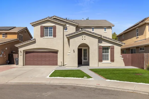 a front view of a house with a yard and garage