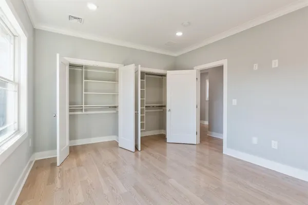 a view of empty room with wooden floor and window