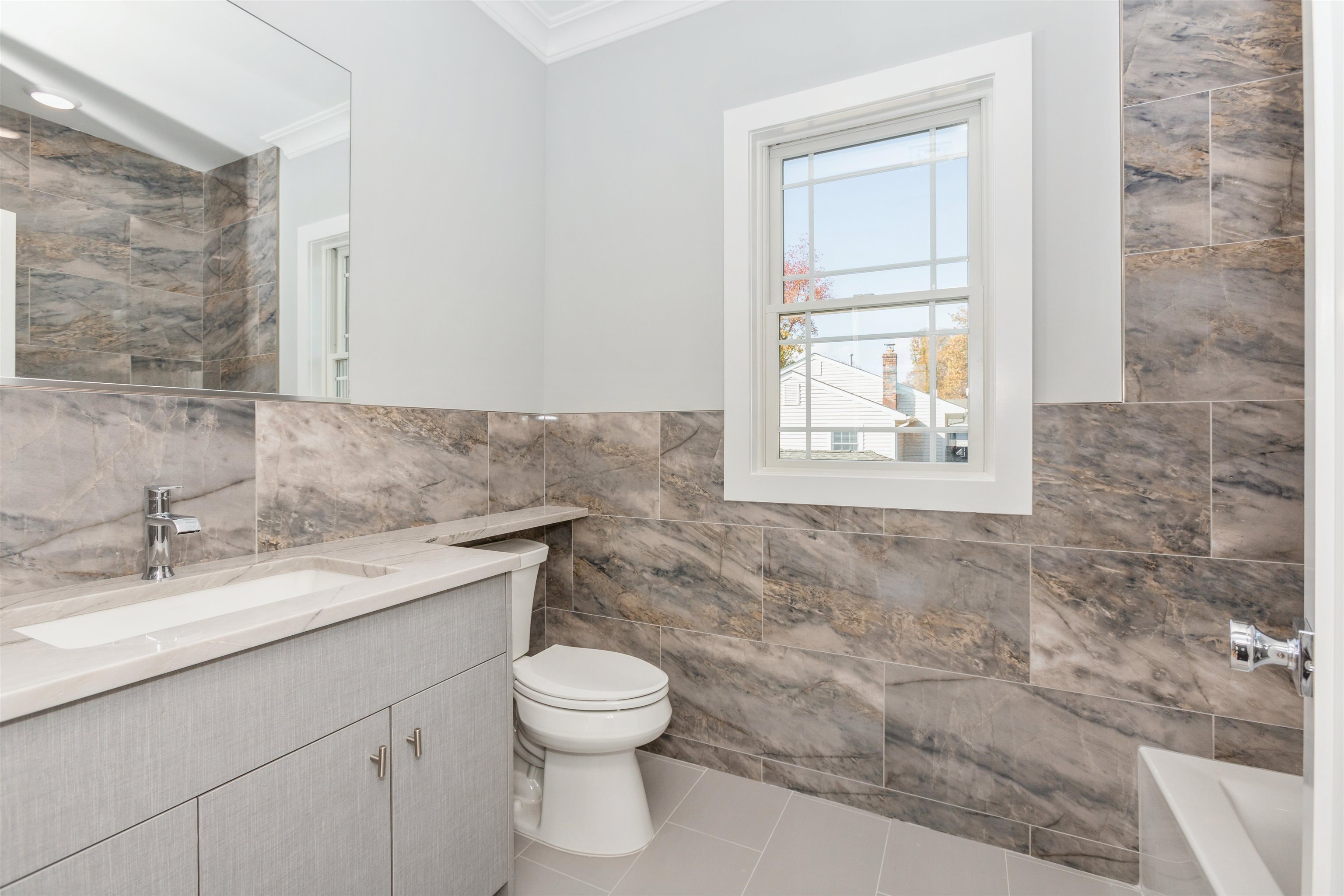 8 Gregory Road Springfield, NJ 07081 - Photo 15 of 30 a bathroom with a granite countertop toilet a sink and a window