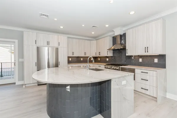 a kitchen with stainless steel appliances granite countertop a sink a stove a refrigerator a white table and chairs