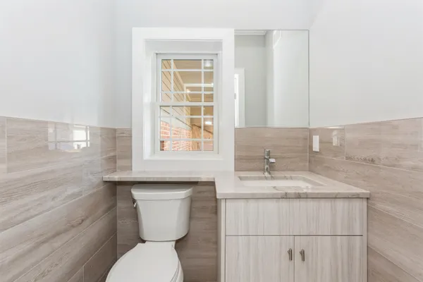 a bathroom with a granite countertop toilet sink and mirror