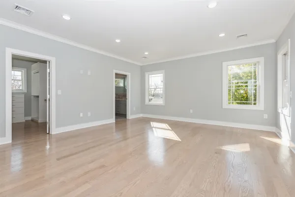 an empty room with wooden floor and a window