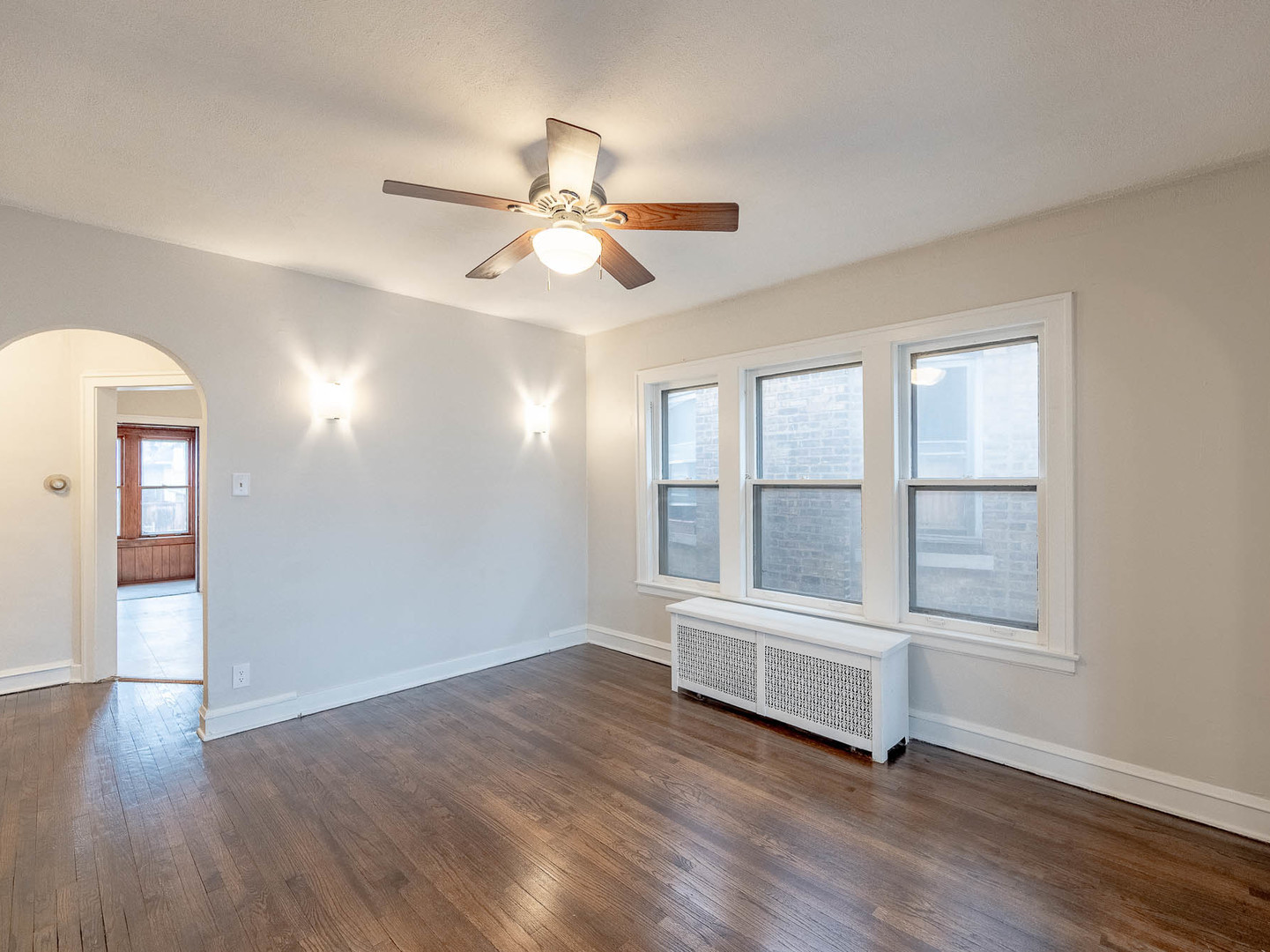 5238 West Wolfram Street Chicago, IL 60641 - Photo 4 of 15 an empty room with wooden floor fan and windows