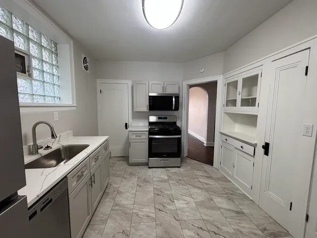 a kitchen with granite countertop a refrigerator and a sink