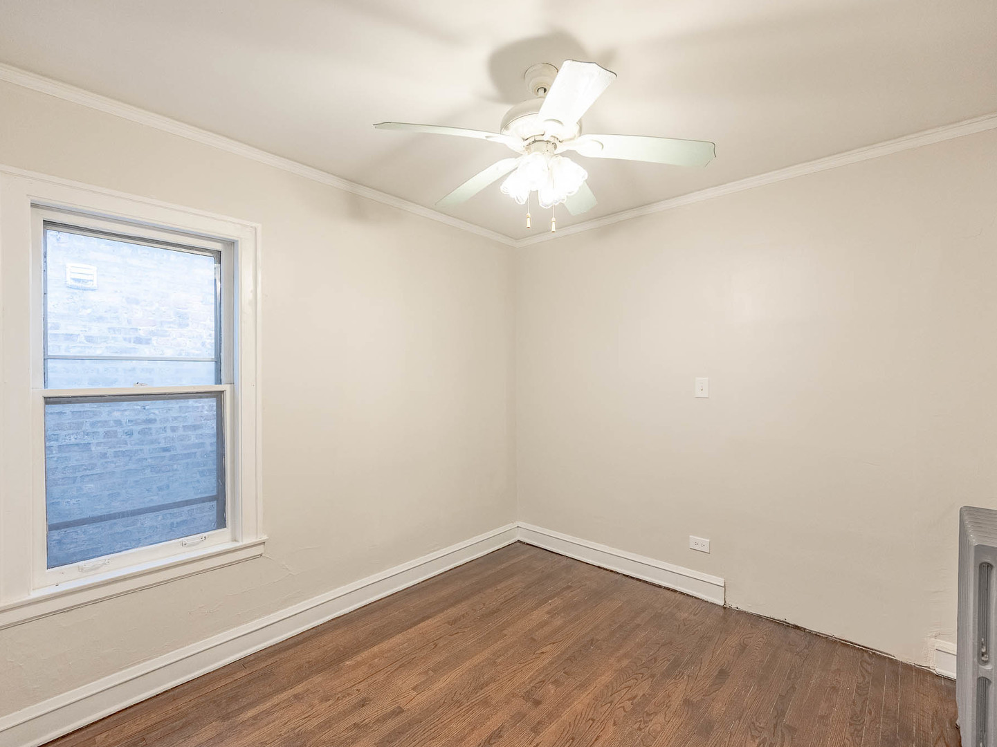 5238 West Wolfram Street Chicago, IL 60641 - Photo 8 of 15 an empty room with wooden floor fan and windows