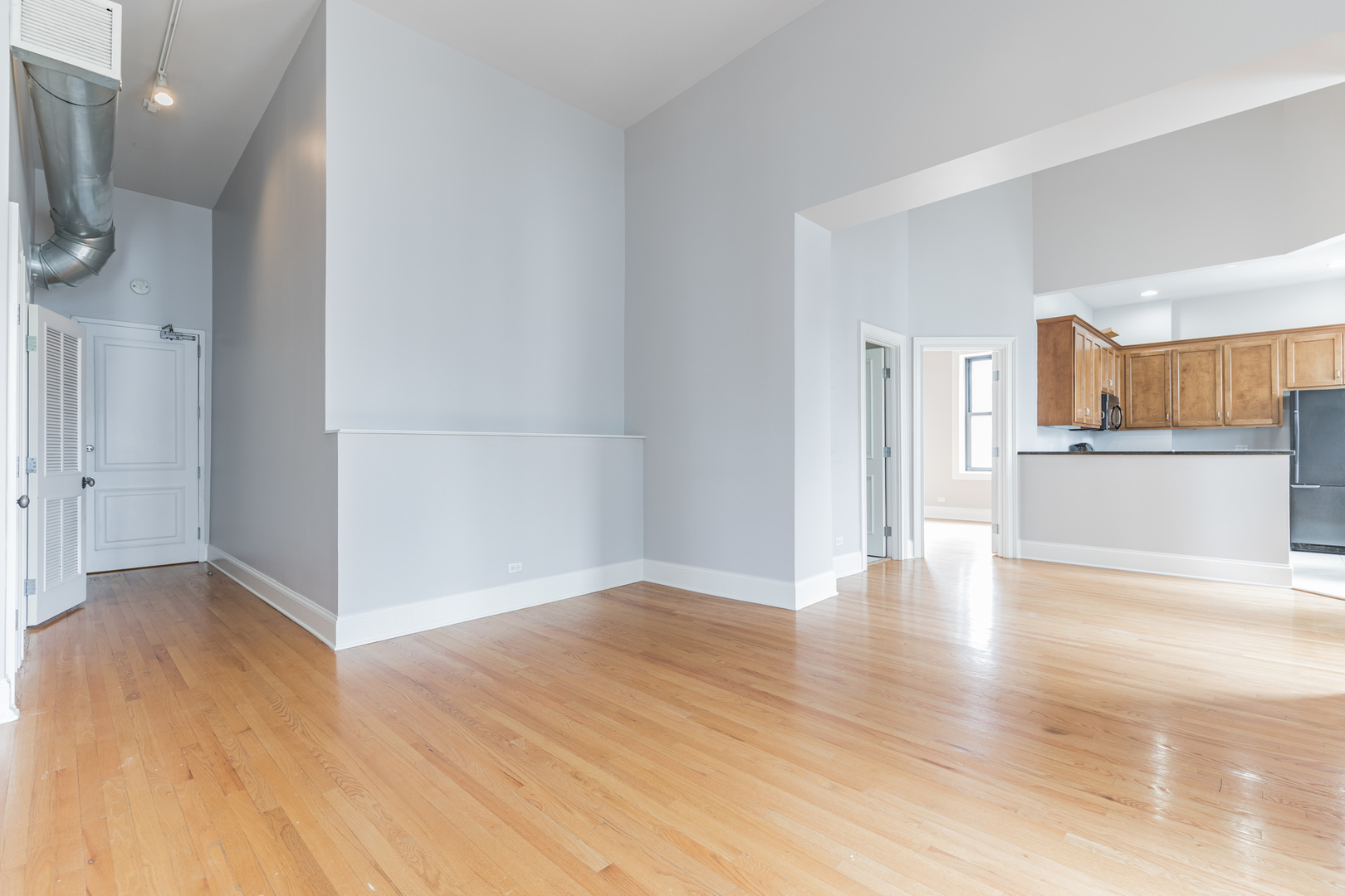 166 West Grand Avenue, Unit 3B Chicago, IL 60654 - Photo 13 of 16 a view of a kitchen with wooden floor and a refrigerator