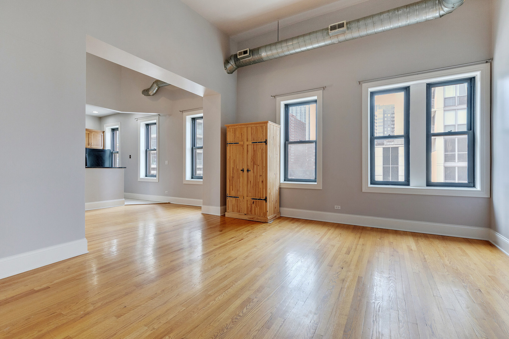166 West Grand Avenue, Unit 3B Chicago, IL 60654 - Photo 2 of 16 a view of an empty room with wooden floor and a window
