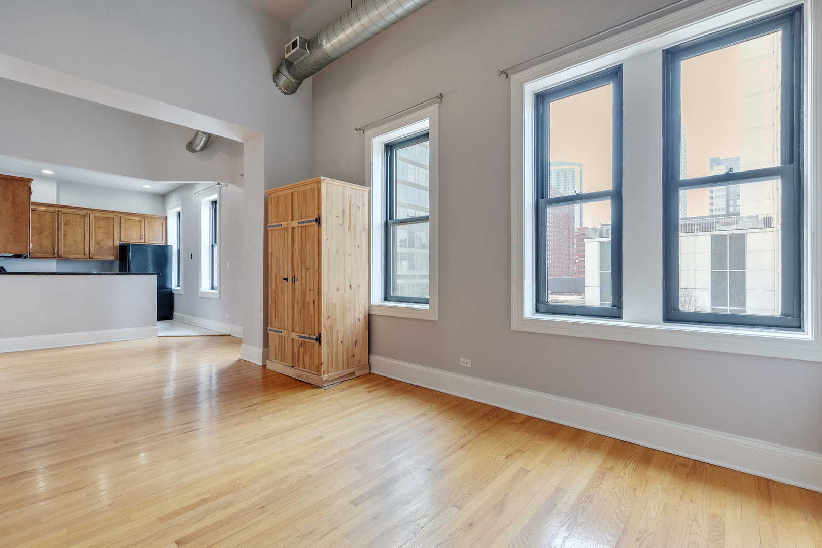 166 West Grand Avenue, Unit 3B Chicago, IL 60654 - Photo 3 of 16 a view of an empty room with window and wooden floor